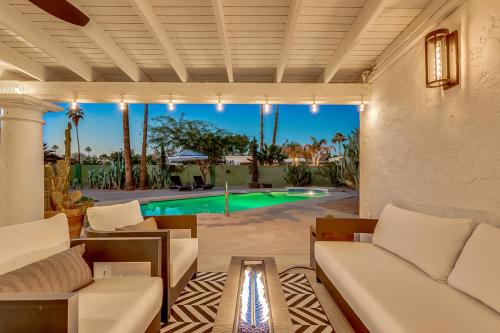 an outdoor living room with white furniture and a swimming pool at Olive Tree Retreat - Heated Pool, Patio & Privacy in Scottsdale