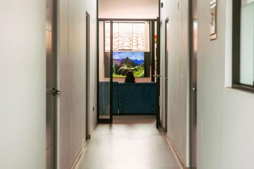 a hallway with a person looking out the window at Net House Cusco in Cusco