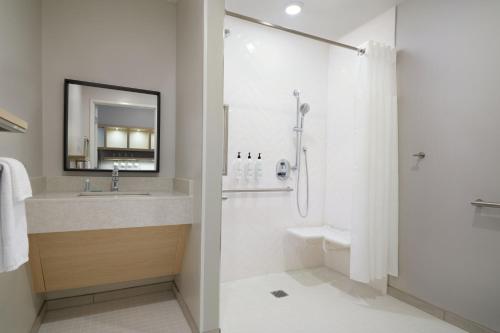 a bathroom with a sink and a shower with a mirror at TownePlace Suites by Marriott Tempe in Tempe