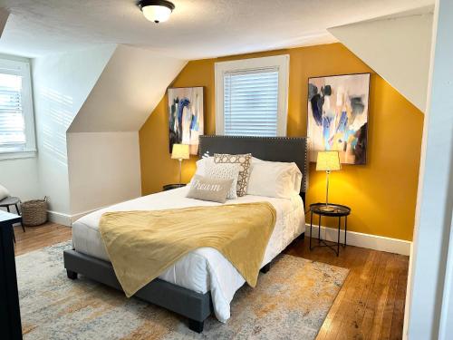 1 dormitorio con 1 cama grande y paredes amarillas en Vibrant City Home 4BD 2BA, en Brockton