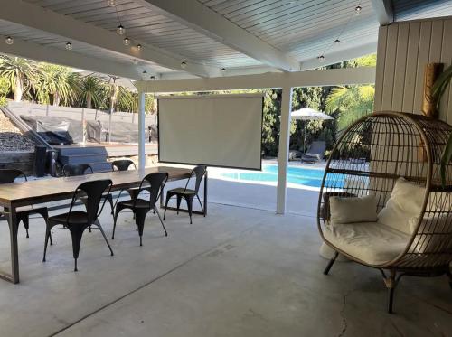 a screened porch with a table and chairs and a screen at Agua Dulce - Mid Century Oasis - Pool &Hot Tub in Spring Valley