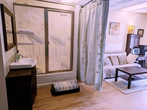 a bathroom with a shower and a sink and a couch at Uptown area, Cozy king Suite, quiet and private, free parking, walk to restaurants in Charlotte