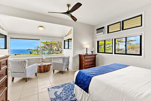 a bedroom with a bed and a desk and windows at Kapalua Ridge Villa 1723-24 in Kahana