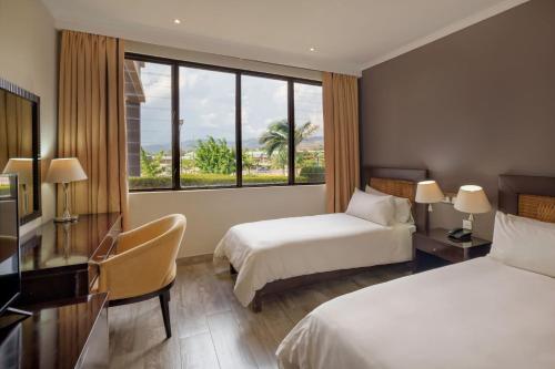 um quarto de hotel com duas camas e uma janela em Protea Hotel by Marriott Chipata em Chipata