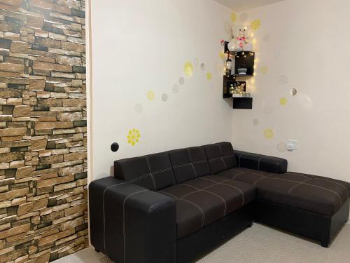 sala de estar con sofá marrón y pared de ladrillo en Residencias Las Flores, en La Paz