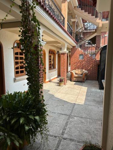 a courtyard of a house with a couch and a building at Posada don Miguel in Panajachel