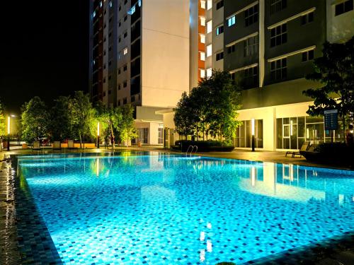 ein großer Pool in der Nacht mit blauen Lichtern in der Unterkunft Alanis Residence Room Sepang KLIA Kota Warisan in Sepang
