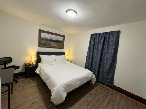 a bedroom with a white bed and a window at Comfy Getaway, 5 Bed, Sleeps 9, walk to falls! in Niagara Falls