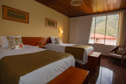 a hotel room with two beds and a window at Hotel El Abuelo in Carhuaz