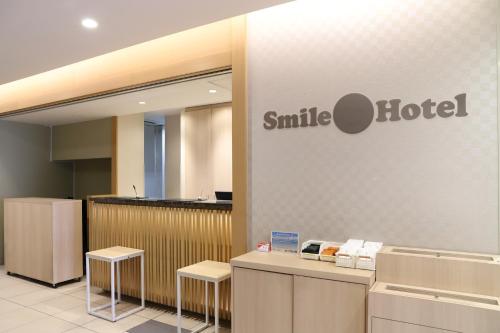 Smile Hotel Osaka Tennoji في أوساكا: ابتسامة لوبي الفندق مع وجود علامة الفندق على الحائط