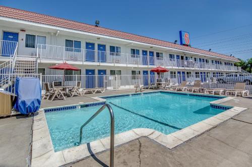 a swimming pool in front of a hotel at Motel 6-Stockton, CA - Charter Way West in Stockton