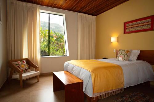 ein Schlafzimmer mit einem Bett und einem großen Fenster in der Unterkunft Hotel El Abuelo in Carhuaz