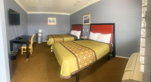 a hotel room with two beds and a desk at Big A Motel in Orange