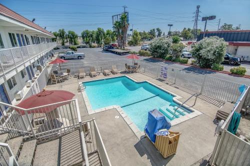 an overhead view of a swimming pool with chairs and umbrellas at Motel 6-Stockton, CA - Charter Way West in Stockton