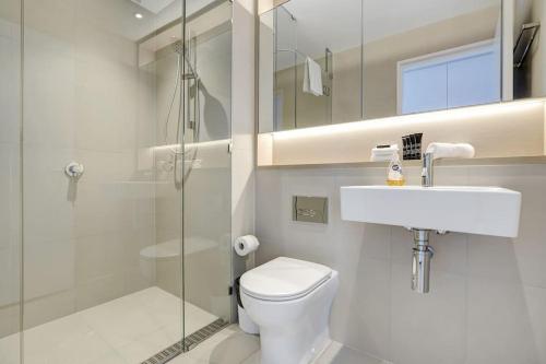 a bathroom with a toilet and a sink and a shower at Wake Up in Front of Water Bay Beckons- 2B2B1C in Melbourne