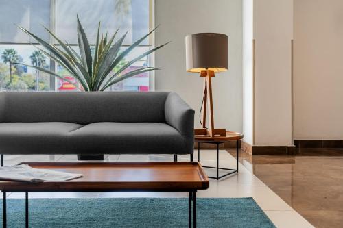a living room with a couch and a table at City Express by Marriott Queretaro Jurica in Querétaro