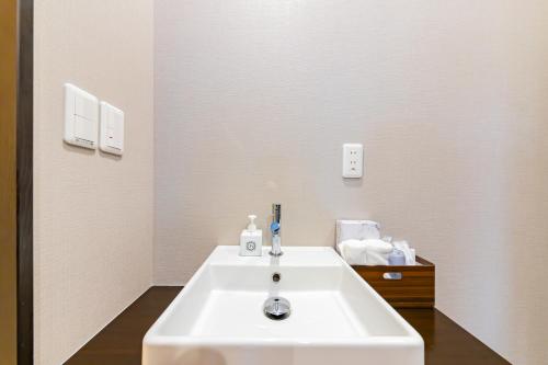 大阪市にあるJA Hotel Shinfukae 新深江のバスルーム(白い洗面台、鏡付)