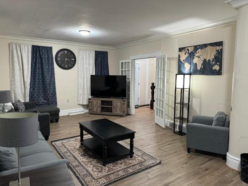 a living room with a couch and a tv at Comfy Getaway, 5 Bed, Sleeps 9, walk to falls! in Niagara Falls