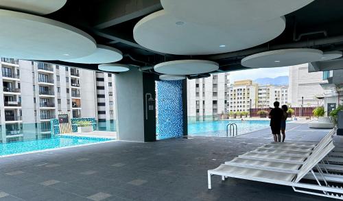a person walking through a building with a pool at Jazz Suites Seaview with Bathtub - 1603 in Tanjong Tokong