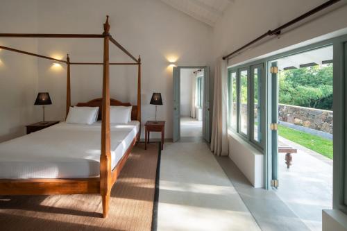 sypialnia z łóżkiem i dużym oknem w obiekcie Villa Poojakanda w mieście Habaraduwa Central
