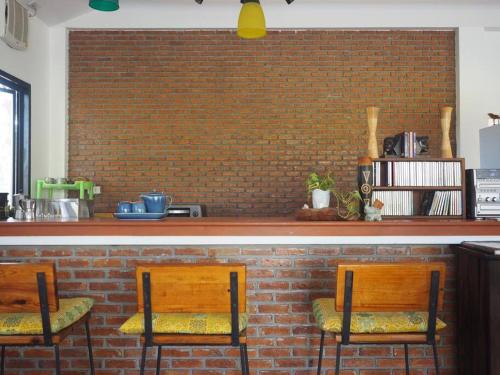 a bar with two wooden chairs and a brick wall at Tea Tree House in Chiang Mai in Chiang Mai