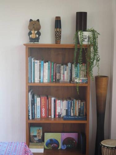 a book shelf filled with books in a room at Tea Tree House in Chiang Mai in Chiang Mai