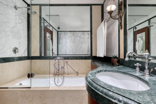 a bathroom with a large tub and a sink at Hotel Grande Bretagne, a Luxury Collection Hotel, Athens in Athens