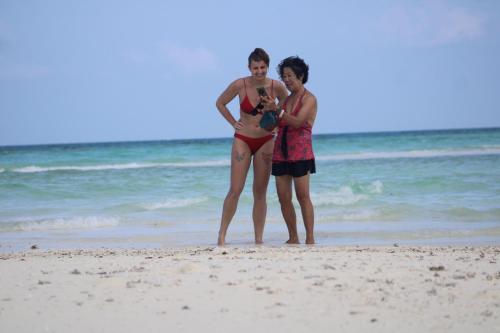 two women in bathing suits standing on the beach at Finimas Residence in Thimarafushi