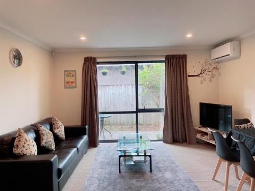 a living room with a couch and a glass table at 2 Bedroom house in Hamilton Central in Hamilton