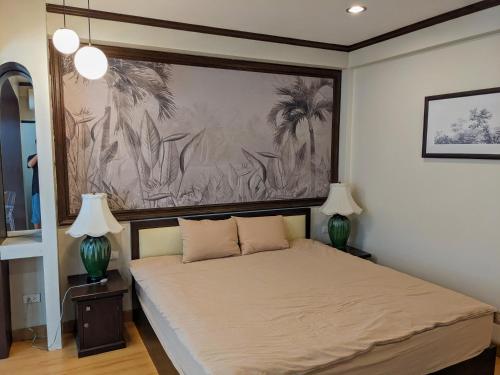 1 dormitorio con 1 cama con 2 lámparas y 1 pintura en October Hostel ChiangMai en Chiang Mai