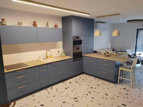 a kitchen with blue cabinets and a sink and a chair at Red Sea Icon in Eilat