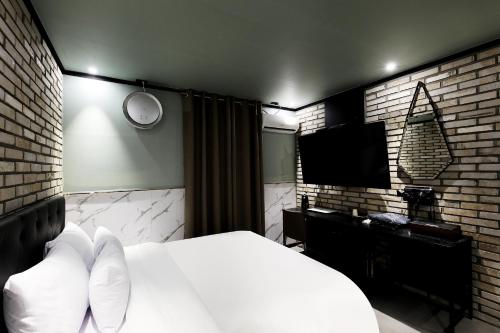 a bedroom with a bed and a flat screen tv at Stay 25 Hotel in Seoul