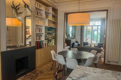 a living room with a table and a fireplace at Atypical house with garden in Paris