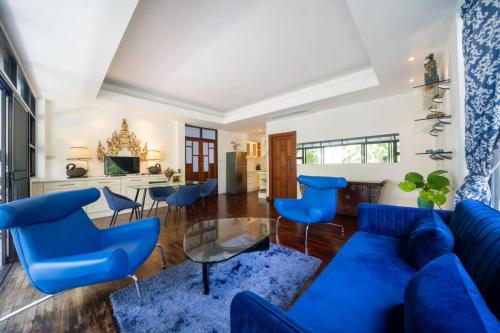 ein Wohnzimmer mit einem blauen Sofa und Stühlen in der Unterkunft Kamala Beach Estate Resort - SHA Extra Plus in Kamala Beach