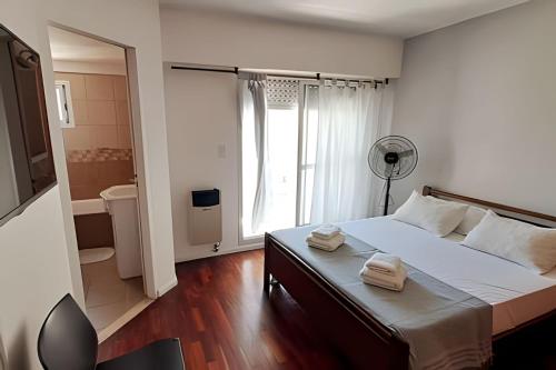 1 dormitorio con 1 cama con 2 toallas en Hornera San Juan - Luminoso Apartamento con Balcón en Rosario