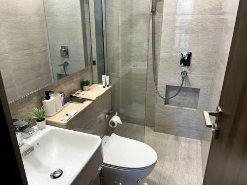 a bathroom with a toilet and a sink and a shower at 1BHK in Hiranandani Powai (E) in Mumbai