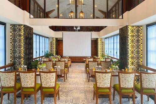 a conference room with tables and chairs and a whiteboard at THE 1O1 Yogyakarta Tugu in Yogyakarta