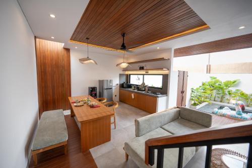 a living room with a couch and a table at Omkara Dharman Ubud Villa By Omkara Experience in Ubud