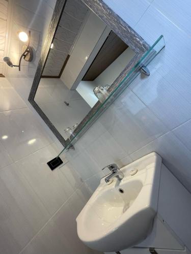 a white bathroom with a sink and a mirror at Net House Cusco in Cusco