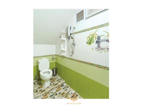 łazienka z białą toaletą i zielonymi kafelkami w obiekcie The Crystal Ranong No201 w mieście Ban Lum Than