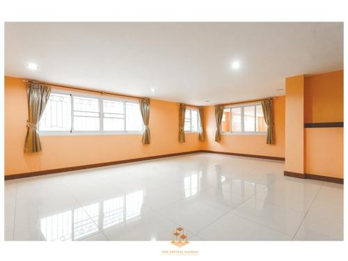 an empty room with orange walls and a dance floor at The Crystal Ranong 201 Cozy luxe room in Ban Lum Than