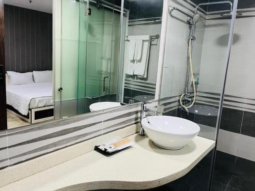 河內的住宿－My House Hotel Hanoi，一间带水槽和镜子的浴室以及一张床
