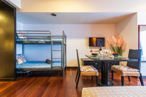 een kamer met een bed, een bureau en een stapelbed bij Resort Suite 6pax Homestay at Sunway Pyramid&Sunway Lagoon in Petaling Jaya