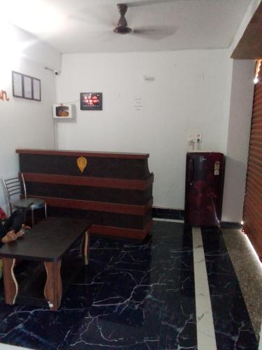 um quarto com um piano e um banco num quarto em Guru guest house bodhgaya em Gaya