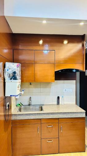 una cocina con armarios de madera y fregadero en Star Comfort Inn en Lucknow