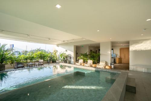 a large swimming pool in a building with a pool at The Rise Suites Hotel, Chiang Mai - SHA Extra Plus in Chiang Mai