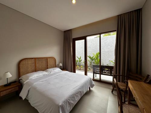 a bedroom with a bed and a large window at Gria Kerten in Solo