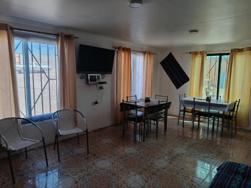 サン・ペドロ・デ・アタカマにあるMisky Wasiのリビングルーム(テーブル、椅子、テレビ付)