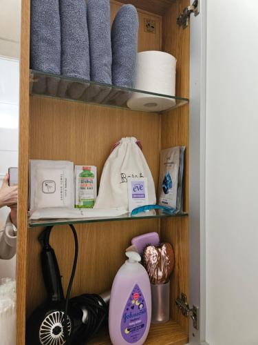a shelf with towels and toiletries in a bathroom at Gangnam Station Fun House in Seoul