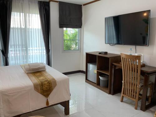 um quarto com uma cama e uma televisão de ecrã plano em Lemon Guesthouse em Chiang Mai